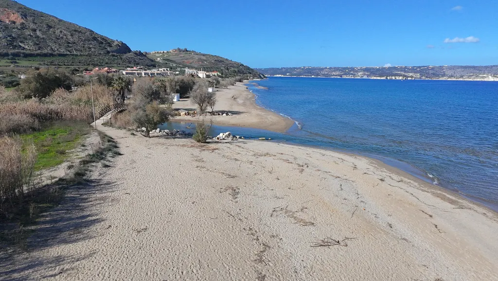 White sandy beach and clear turquoise waters defining Kiani Akti Beach on the Cretan coast.